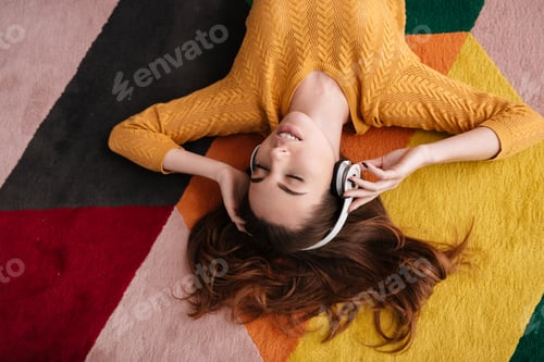 Preview: Portrait of a young pretty girl in headphones enjoying music