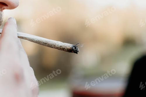 Preview: Closeup shot of a male smoking a cigarette on a blurred background