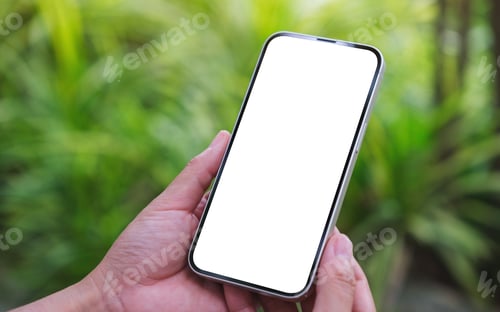 Preview: Mockup image of a woman holding mobile phone with blank white desktop screen in the garden
