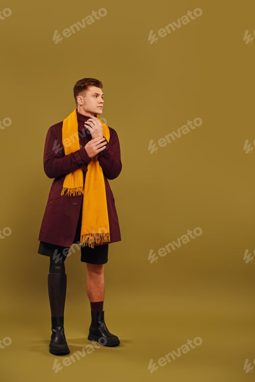 Preview: Confident young man with prosthetic leg showcasing modern fashion in a stylish studio