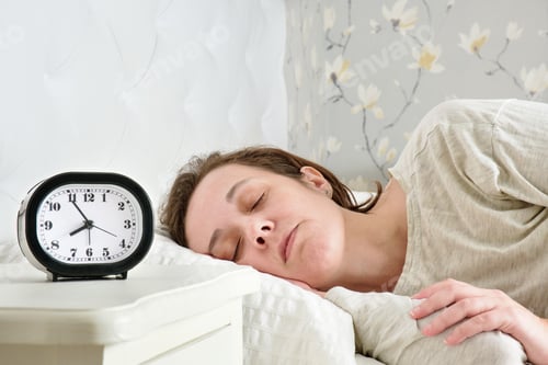 Preview: woman lying in bed sleeping peacefully not caring about the alarm clock time
