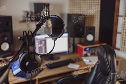 Preview: Focus on professional microphone and headphones in the blurred workplace
