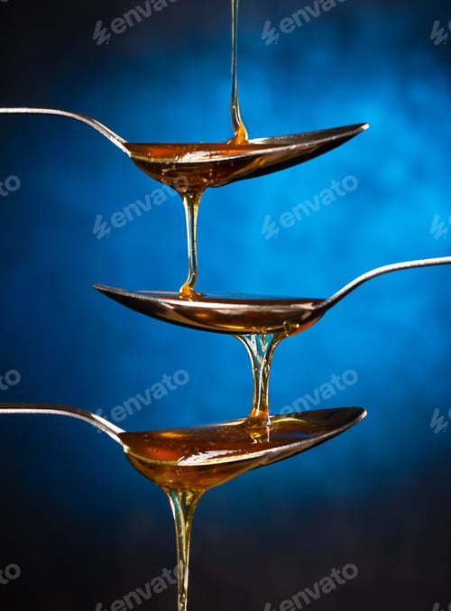 Preview: Golden sweet honey spilling over colorful background