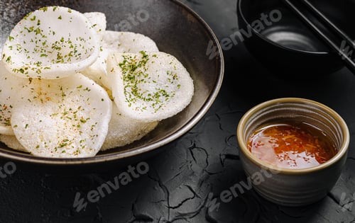 Preview: Crunchy rice crackers served with dipping sauce and herbs