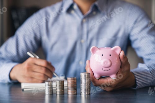 Preview: Close-up image of man hand putting coins in piggy bank for account save money. Planning step up, sav