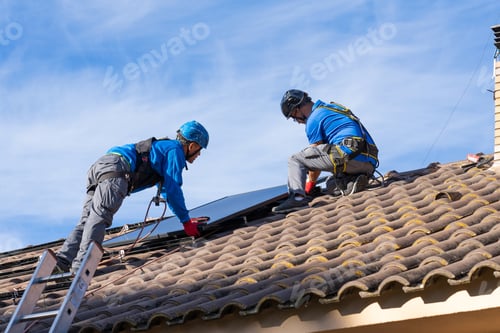 Preview: Two men on the roof of a house installing solar panels