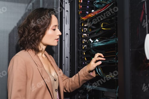 Preview: technician checking wires in server while working in data center