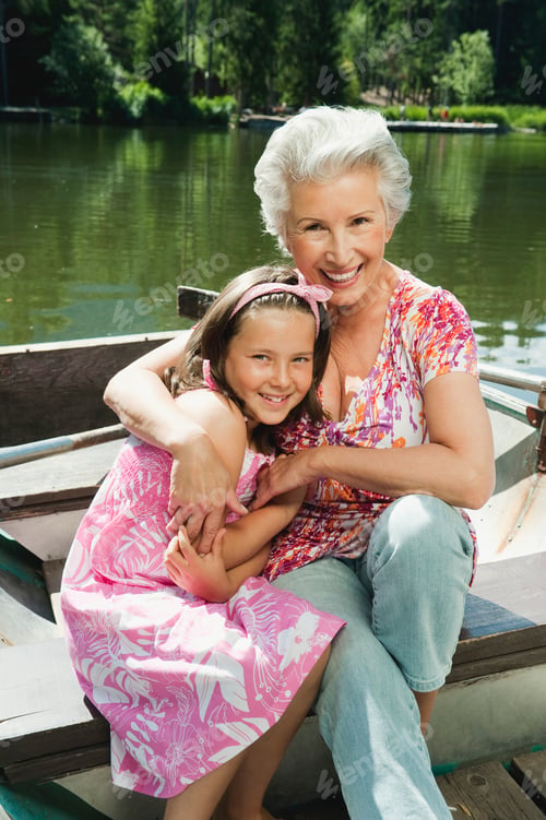 Preview: Italy, South Tyrol, Grandmother and granddaughter (8-9) sitting in rowing boat, smiling, portrait