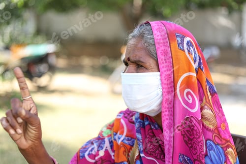 Preview: Closeup shot of an Indian woman with a traditional dress and white mask