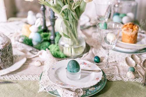 Preview: happy easter holiday in springtime season. painted green emerald colored chicken egg in bowl and pla