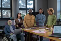 Preview: Group of multiracial colleagues standing by table in boardroom