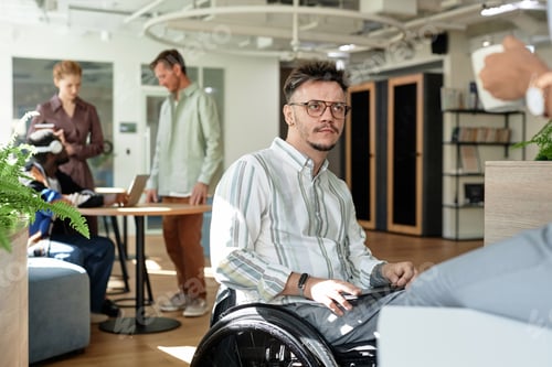 Preview: Businessman with disability talking to colleague