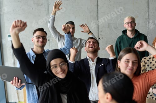 Preview: A diverse team of business professionals ecstatically celebrating their success in a modern office