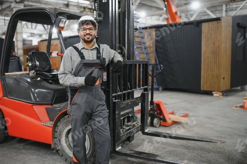 Preview: Arab engineer gesturing thumbs up near forklift in modular house factory