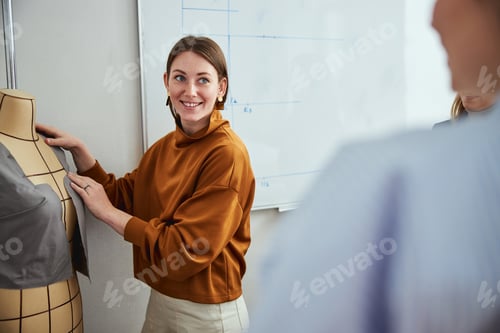 Preview: Shy clothes designer near tailor dummy staring at male