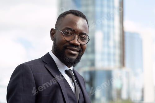 Preview: Happy young African businessman in formalwear looking at camera