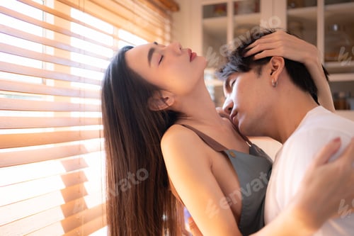 Preview: Young asian couple show each other affection in the kitchen at home. Happy family concept.