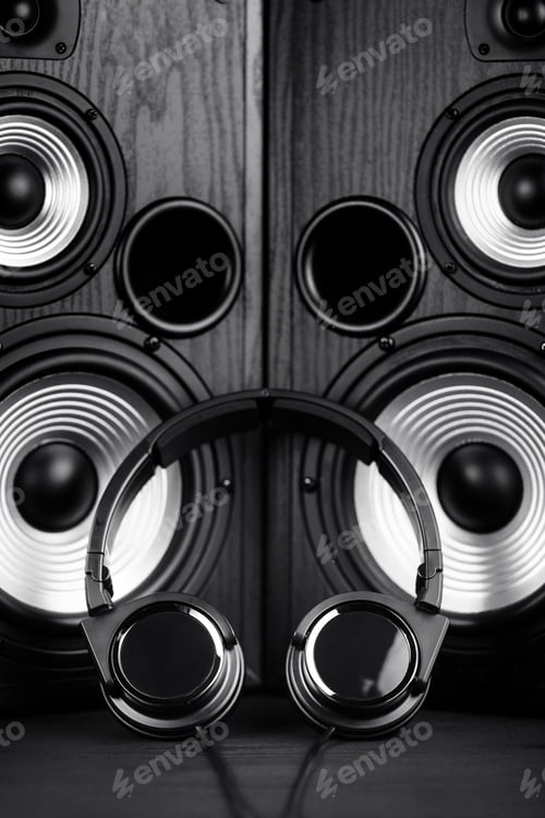 Preview: Photo of black music audio speaker and headphones. Close-up.