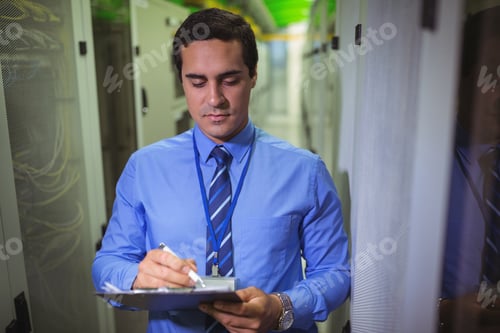 Preview: Technician Maintaining Record Of Rack Mounted Server On Clipboard In Server Room