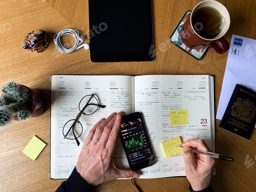 Preview: Overhead workspace: view of a male hands and working station with notebook, tablet, glasses, tea mug