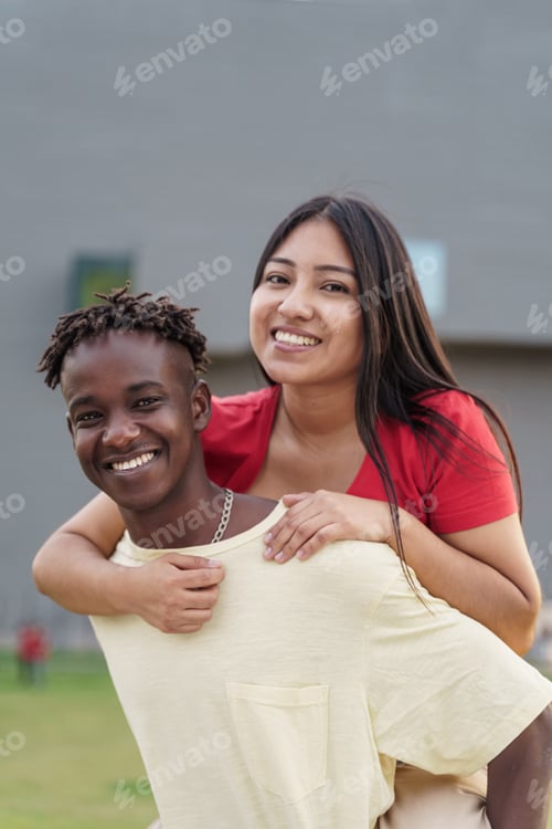 Preview: Lovely multi ethnic African and Latin couple or friends piggybacking in the city. Focus on the