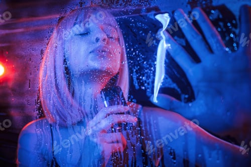 Preview: Vaping, holding device. Stylish woman with white hair is behind wet transparent plastic sheet