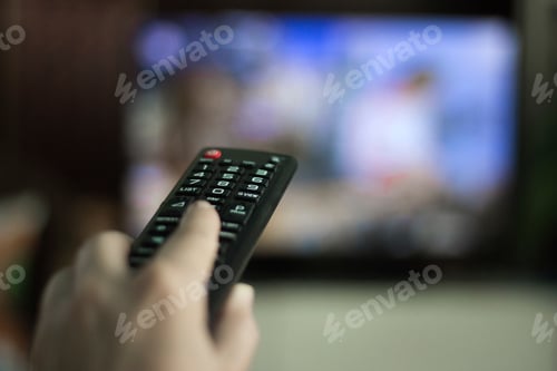 Preview: Close up of hand holding tv remote control
