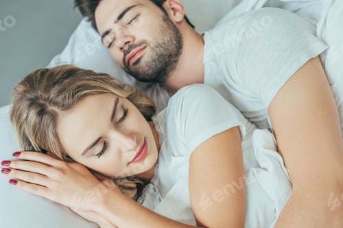 Preview: close-up shot of beautiful young couple sleeping together in bed at home