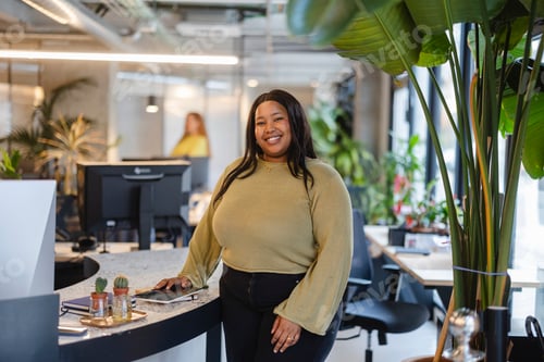 Preview: Confident plus size businesswoman smiling in modern green office environment