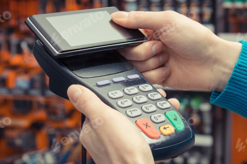 Preview: Hand of woman using payment terminal and smartphone