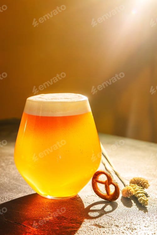 Preview: Close up glass of non-filtered light beer with pretzels, festive dinner party celebration weekend