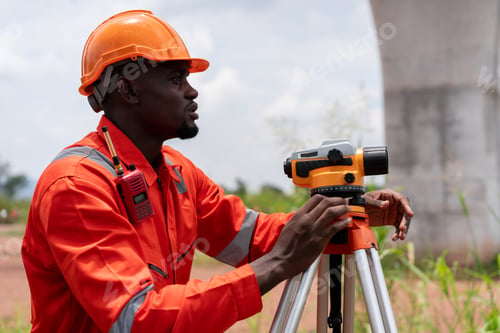 Preview: Surveyors and engineers using a theodolite and plans to measure during road construction.