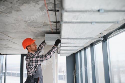 Preview: Construction worker installing ventilation system in building