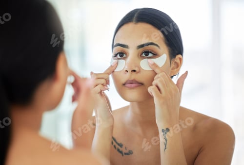 Preview: My puffy eyes will be gone in no time. Shot of a young woman using eye masks in a bathroom at home.