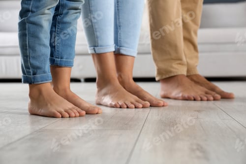 Preview: Family with little child together at home, closeup. Floor heating concept