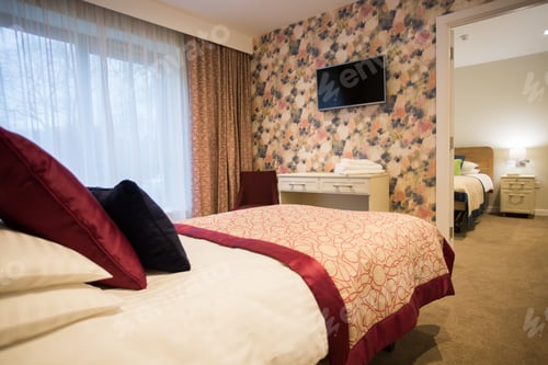 Preview: Shot of a stylish bedroom interior with a modern TV attached to a textured painted wall