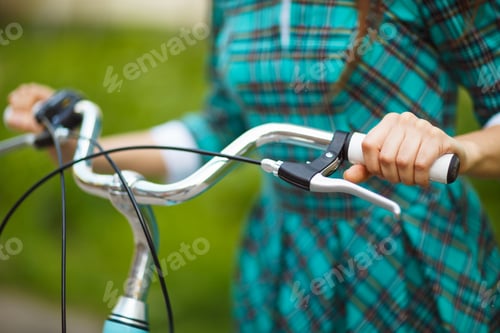 Preview: Girl walking with her bicycle outdoors