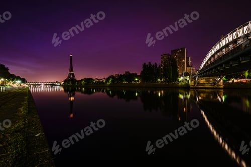 Preview: A view along the water of the River Seine at night