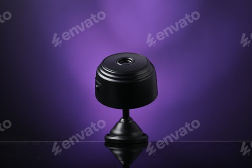 Preview: Modern hidden spy camera on mirror surface against purple background, closeup