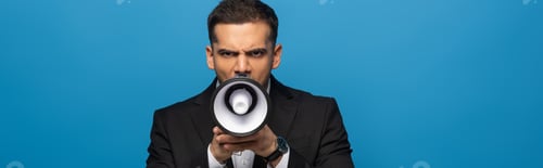 Preview: Panoramic shot of businessman screaming in loudspeaker isolated on blue
