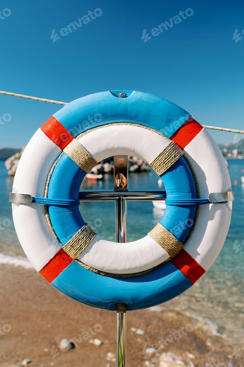Preview: Large and small lifebuoy hanging on a rack on the seashore