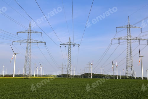 Preview: Field with high-voltage masts against the blue sky