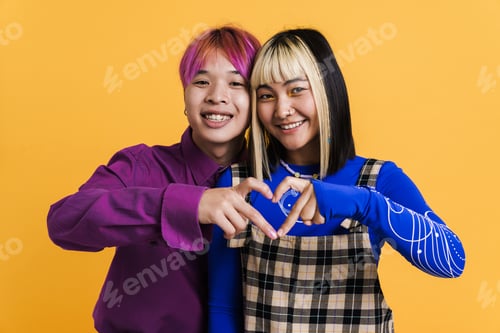Preview: Asian couple smiling while showing heart gesture together