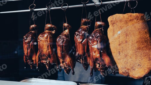 Preview: Roasted ducks hanging from metal meat hooks in the window of a chinese restaurant