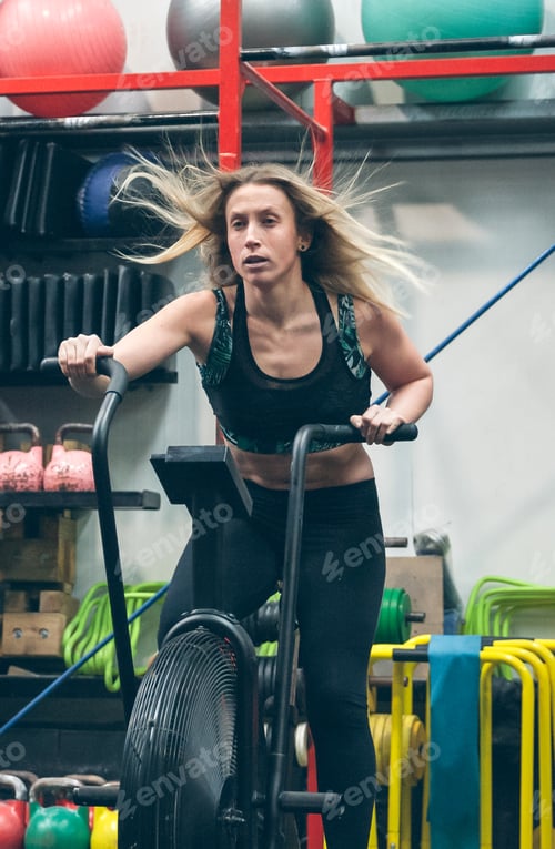 Preview: Sportswoman doing air bike at the gym