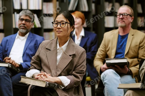Preview: Multiethnic Group of Adults Listening Attentively during Book Seminar
