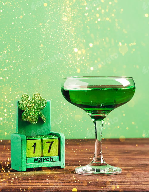 Preview: Traditional drink green beer in an elegant glass with a clover leaf close-up