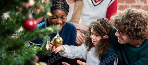 Visualização: Família multiétnica e filha pequena decoram a árvore de Natal em casa.