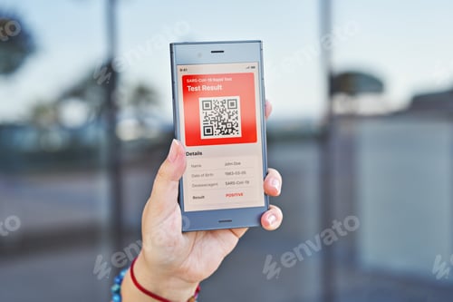 Preview: Hand woman holds smartphone displaying on app positive test result of COVID-19