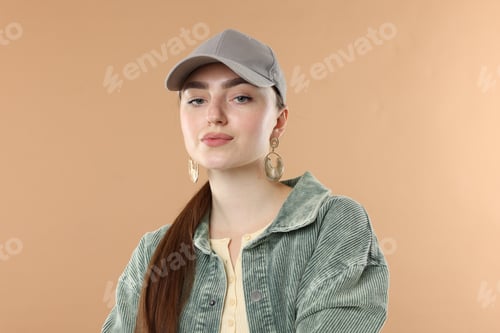 Preview: Portrait of beautiful woman in stylish baseball hat on beige background